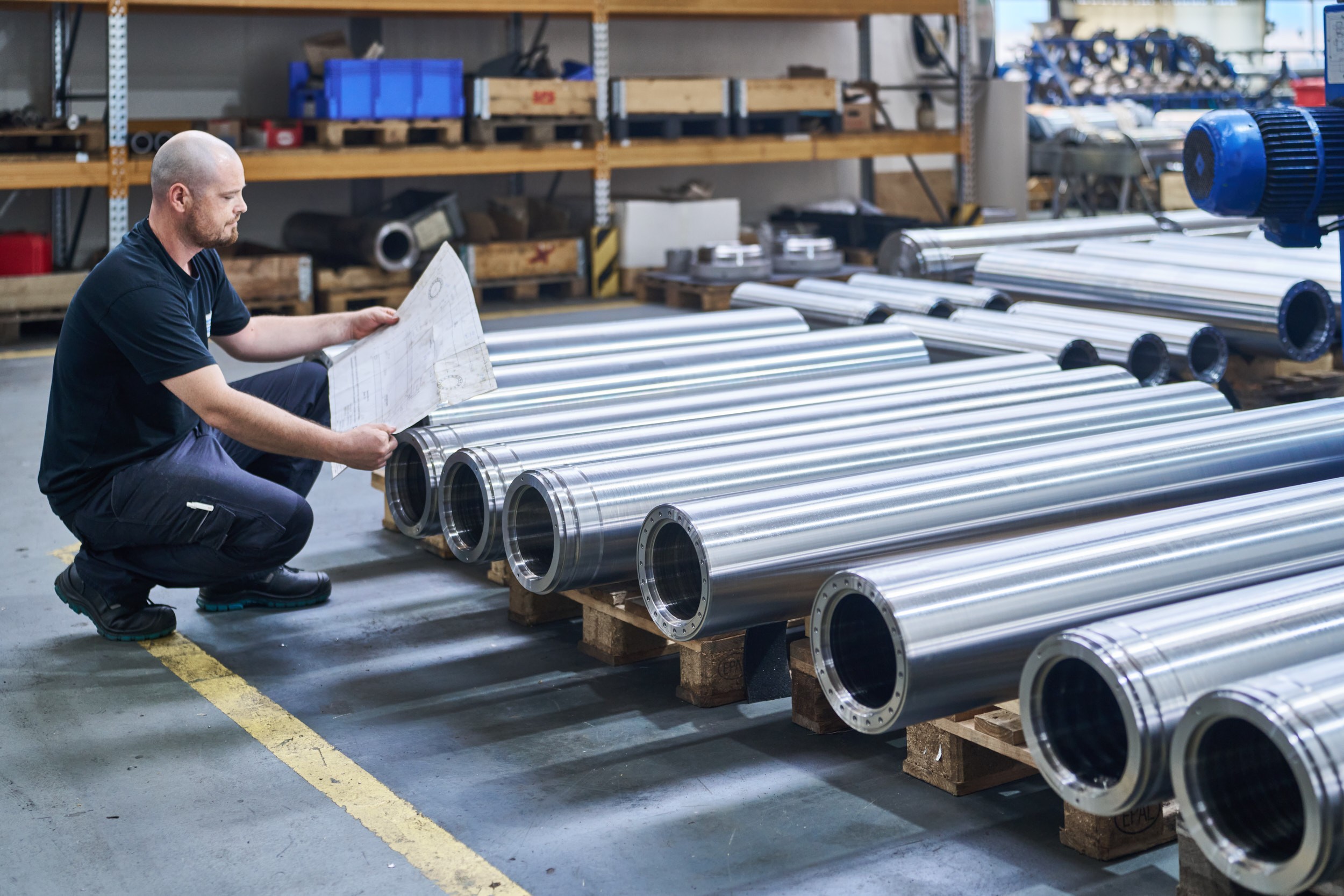 Ein ACONA Angestellter kontrollierte Rohre mit einer technischen Zeichnung