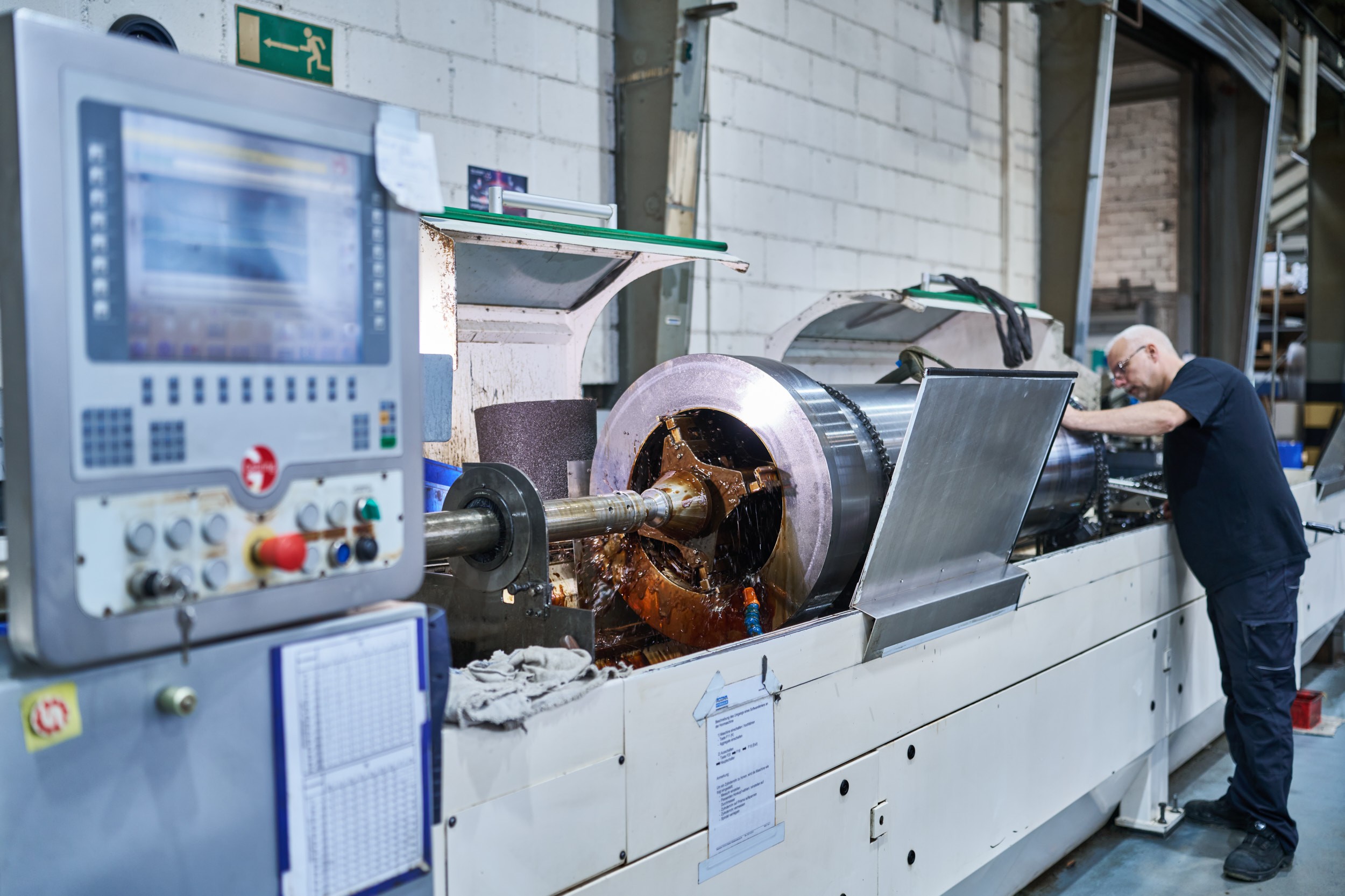 Ein Mitarbeiter von ACONA bedient eine Maschine zur Bearbeitung von Hydraulikzylindern