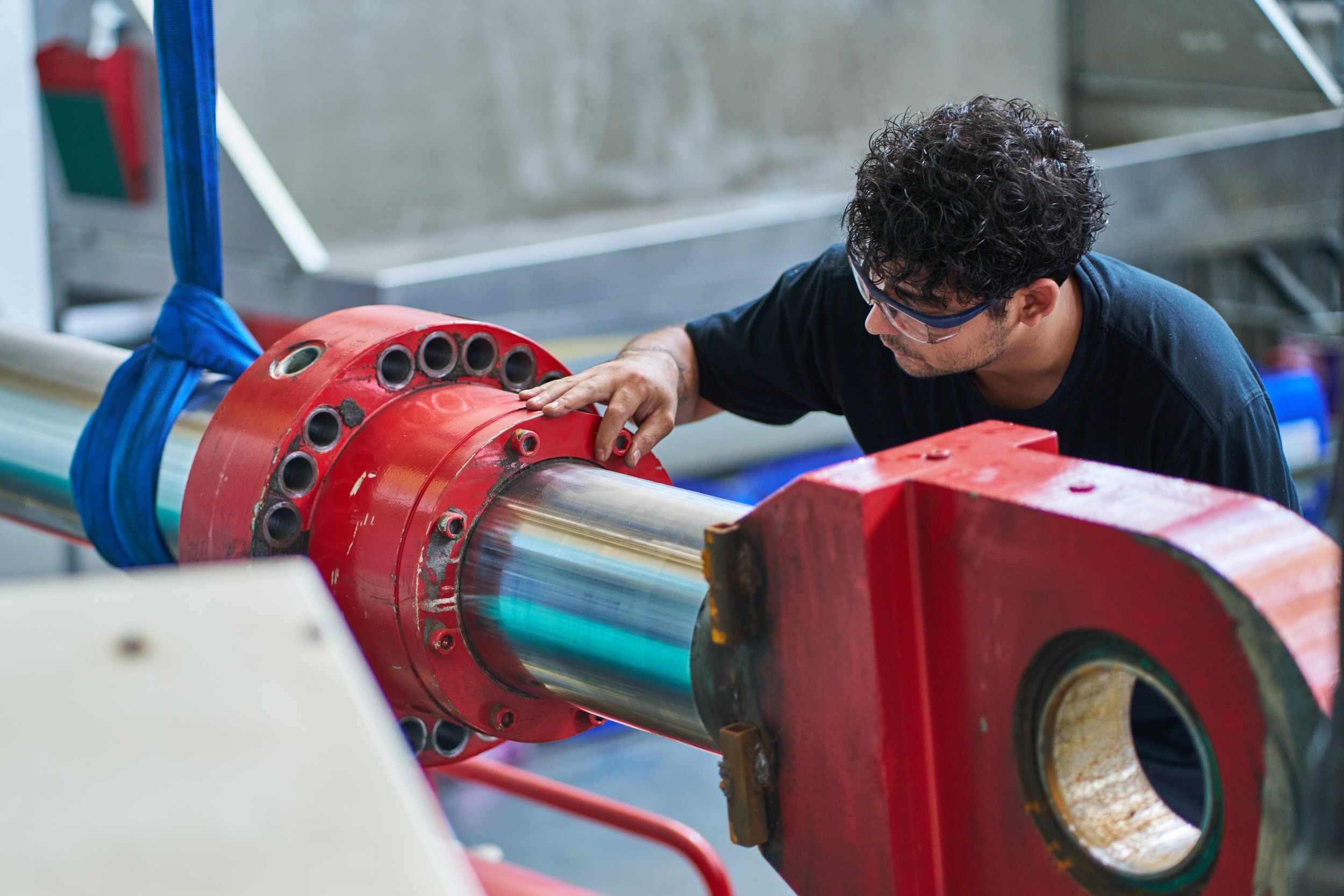 Ein Mitarbeiter von ACONA pr&uuml;ft einen Hydraulikzylinder