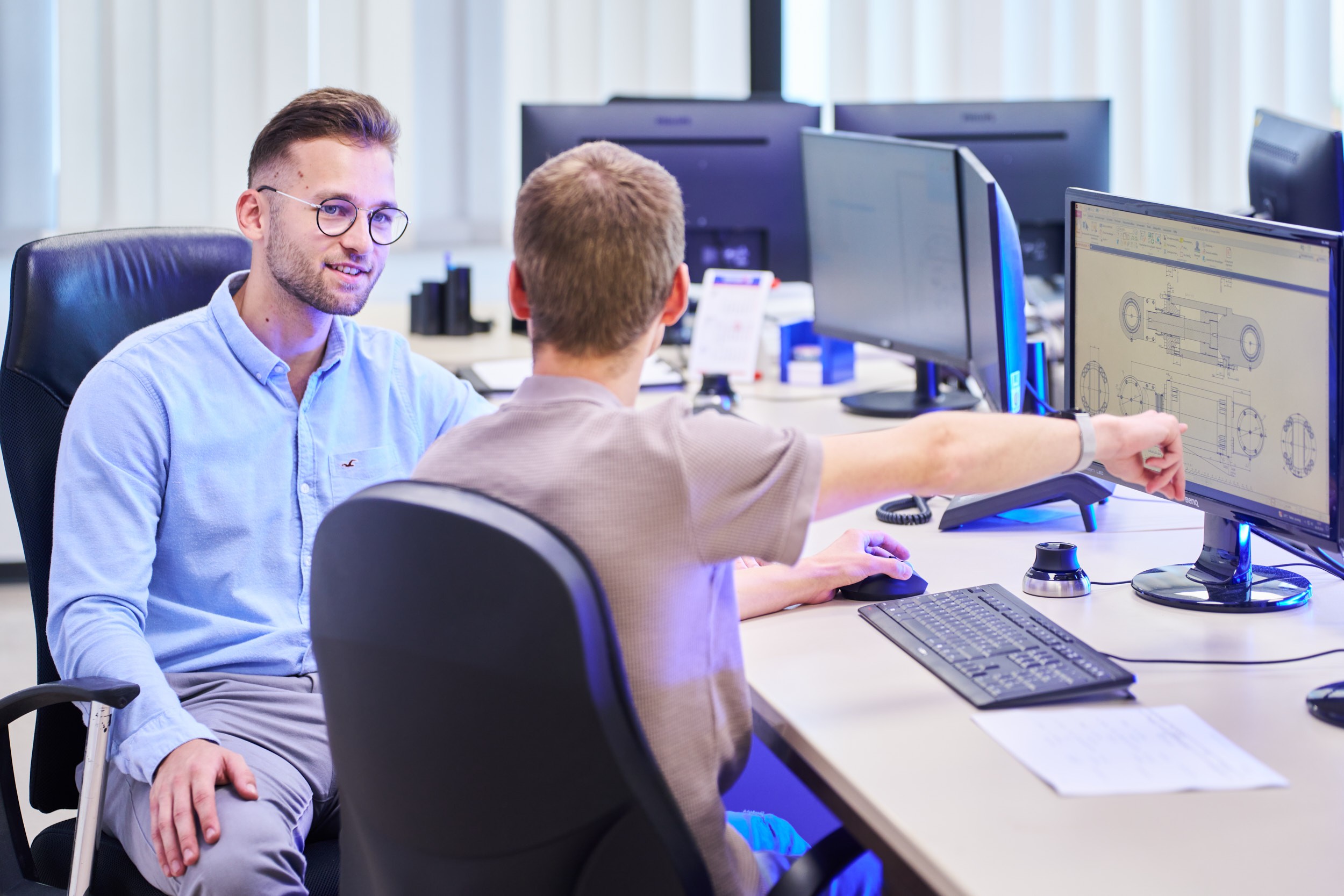 Zwei Mitarbeiter besprechen im B&uuml;ro die digitalen Pl&auml;ne eines Hydraulikzylinders